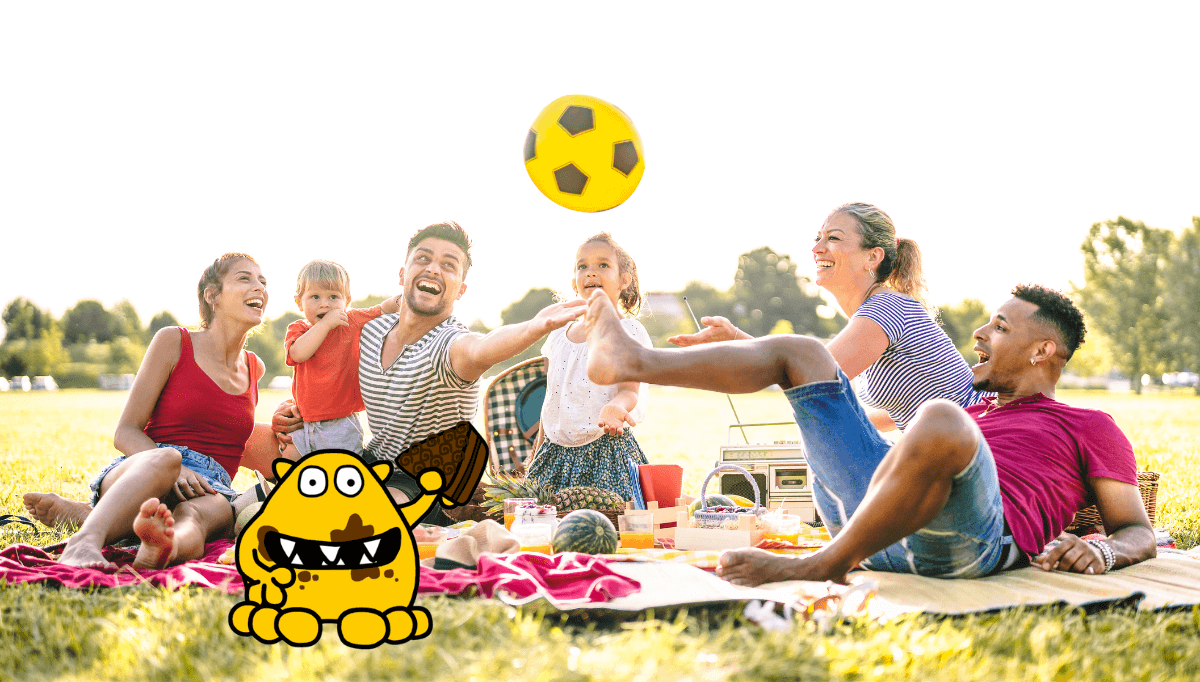 Family summer picnic in the park with children playing and eating – outdoor holiday activity idea